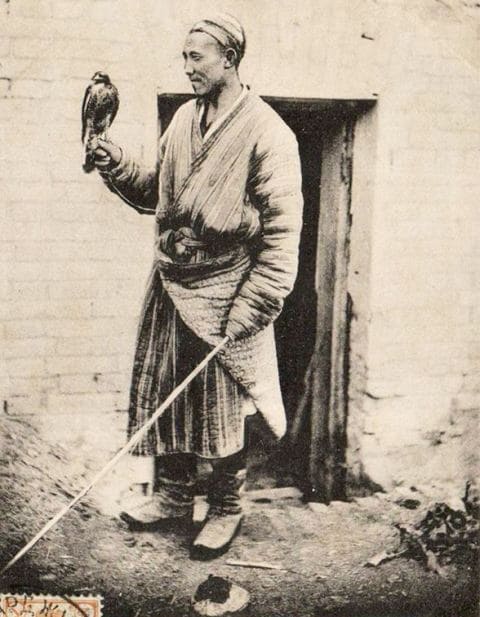 Кыргыз с соколом. Новый Маргилан (Ферганская долина, Узбекистан). Почтовая открытка начала XX века. Снимок был издан в начале XX века как серийная почтовая открытка. В то время крупные издательства Российской империи (например, «Контрагентство А. С. Суворина и Ко» или «Всемирный почтовый союз») массово скупали негативы у разных фотографов-путешественников и местных фотомастеров, часто выпуская открытки без указания имени самого автора снимка. Тем не менее, большинство этнографических фотокарточек этого периода в Туркестанском крае создавались ограниченным кругом известных мастеров. С высокой долей вероятности первоисточником мог быть один из следующих фотографов: Дмитрий Иванович Ермаков - выдающийся военный топограф и фотограф, много путешествовавший по Средней Азии, Персии и Кавказу, чье колоссальное портретное наследие часто выкупалось для печати открыток. Иван Васильевич Чистяков - один из первых профессиональных фотографов Нового Маргелана (Скобелева), который держал там собственное фотоателье и подробно документировал быт местных жителей. Г. А. Панкратьев - военный чиновник, составивший знаменитый многотомный этнографический «Альбом видов Туркестана» на рубеже XIX–XX веков.