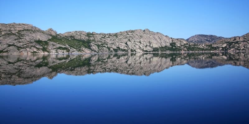 Гранитные стены, поднимающиеся над водой, создают впечатление природной крепости.