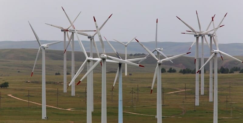 On the Kordai Plateau, after the pass, wind turbines are located to the right of the road.