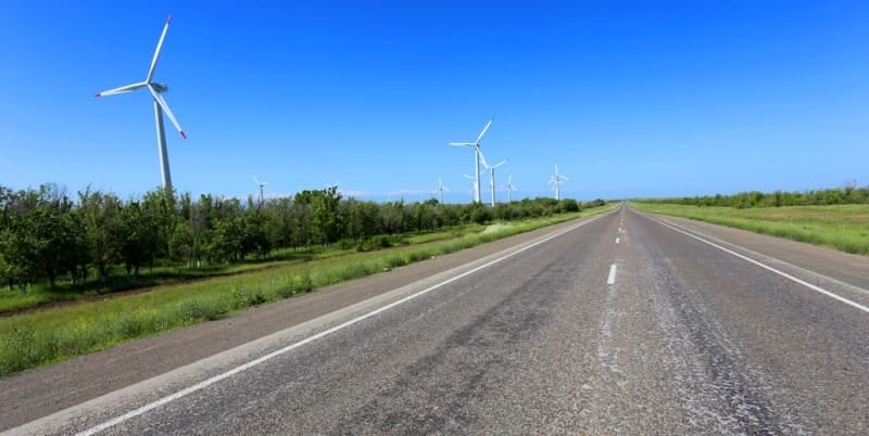 Wind turbines are located on the Kordai Plateau after the pass, to the right of the road. 