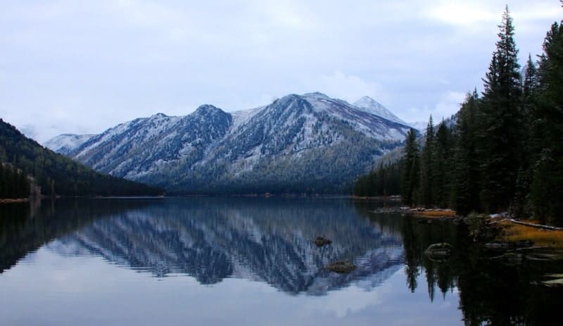 Lake Rakhmanovskoye is located at an altitude of 1,725 meters above sea level in the deep valley of the Arasanka River, a tributary of the Belaya River. The lake's water is a stunning greenish-blue color and very clear. The lake is surrounded by majestic mountains, ancient cedars, and spruce trees. Near the lake are thermal mineral springs, the water of which contains radon.
