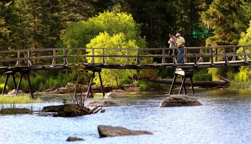 A wooden pedestrian bridge over the Arasan River, which flows out of Lake Rakhmanovskoye.