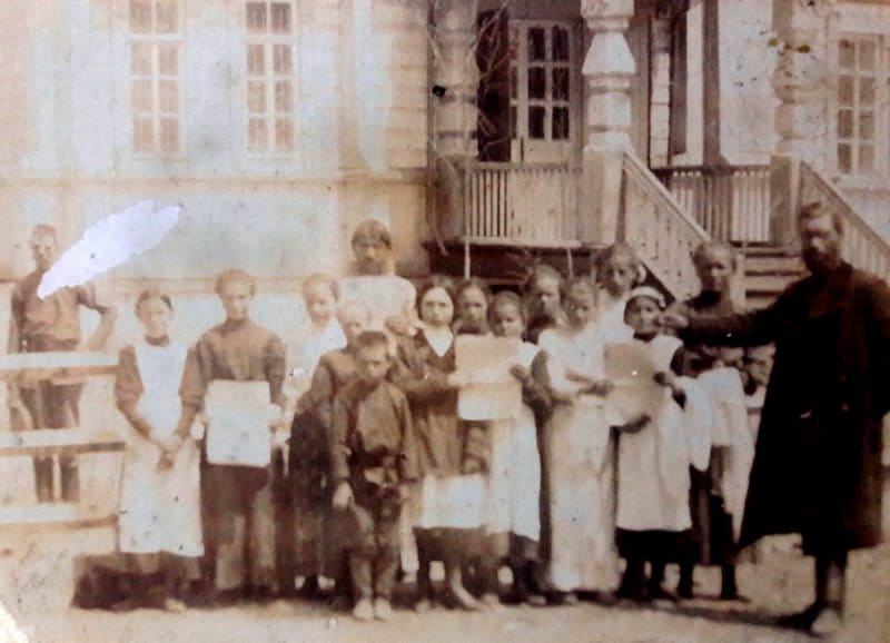 Church choir of girls and boys with notes in their hands, in white aprons. In the center stands the priest. Late XIXth – early XXth centuries. Photographer unknown.