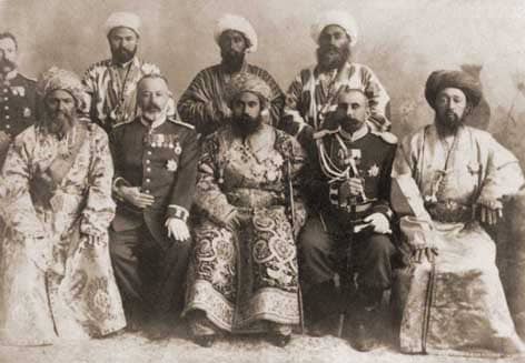 Сеид Абдулахад-хан (сидит в центре), девятый эмир Бухары из династии Мангытов, правивший с 1885 по 1910 год. На фото эмир представлен в окружении своей свиты и представителей Российской империи. В период его правления Бухарский эмират находился под протекторатом России, и Абдулахад-хан поддерживал тесные связи с императорским двором. Слева и справа от эмира сидят офицеры русской армии в парадной форме с многочисленными наградами. Он отменил рабство в эмирате, запретил пытки и провел реорганизацию армии. Эмир часто посещал Санкт-Петербург, был почетным членом Крымско-Кавказского горного клуба и имел высшие ордена Российской империи. После его смерти в 1910 году трон занял его сын, Сейид Алим-хан, ставший последним эмиром Бухары.